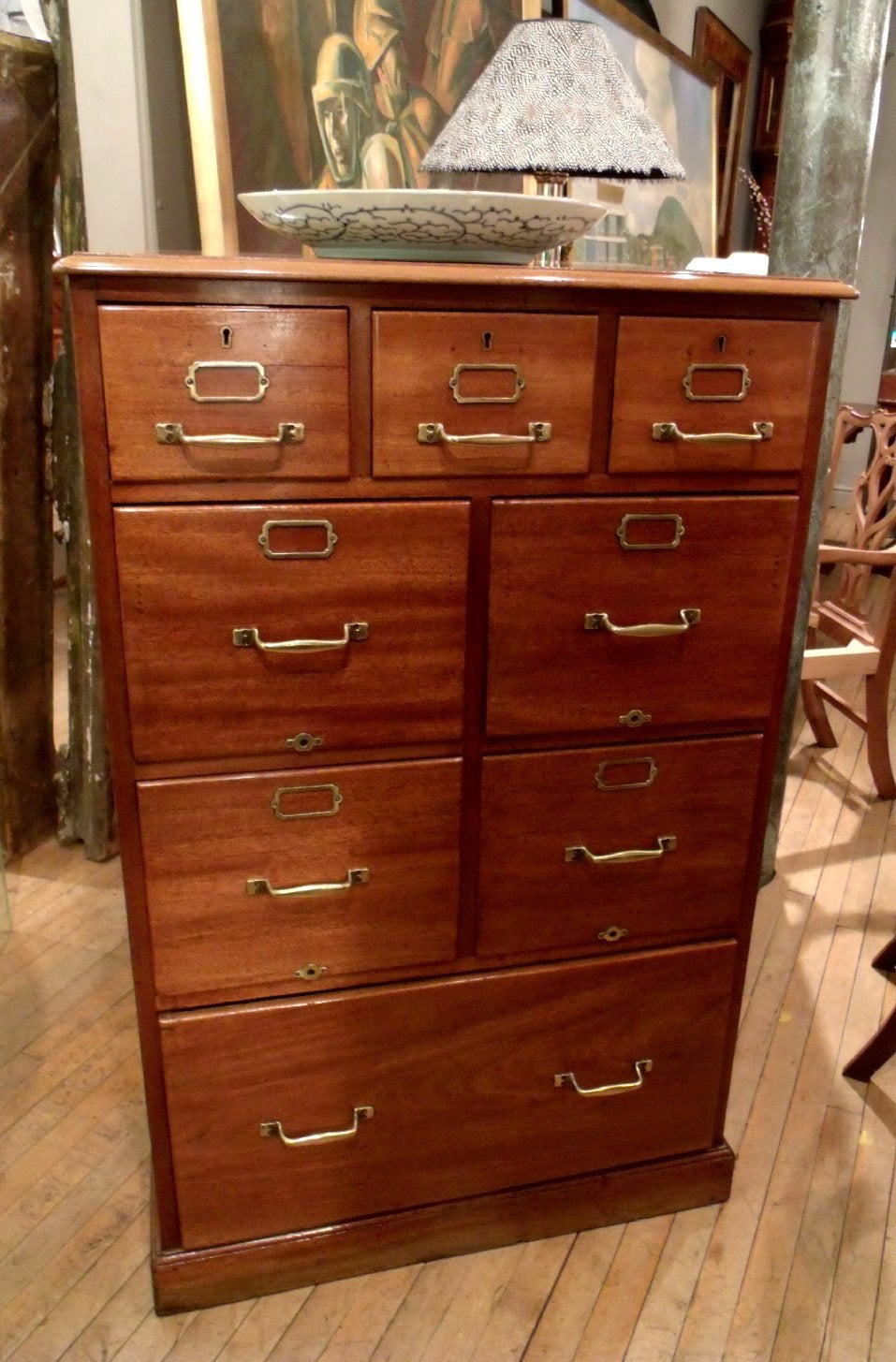 This excellent quality and wonderfully paginated mahogany filing cabinet features brass hardware and trim in a well-proportioned size. There are 4 central good sized file drawers between 3 smaller drawers on top and a large, deep bottom drawer. The