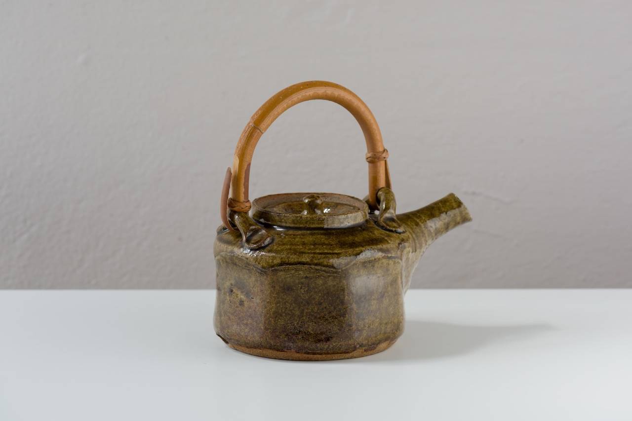 Here is a beautifully functional teapot by the veteran potter Warren McKenzie. Graceful, balanced, easy to handle, and expressive.  The clay body is light brown stoneware with specks of iron.  Faceted with an inset lid and surprisingly light for
