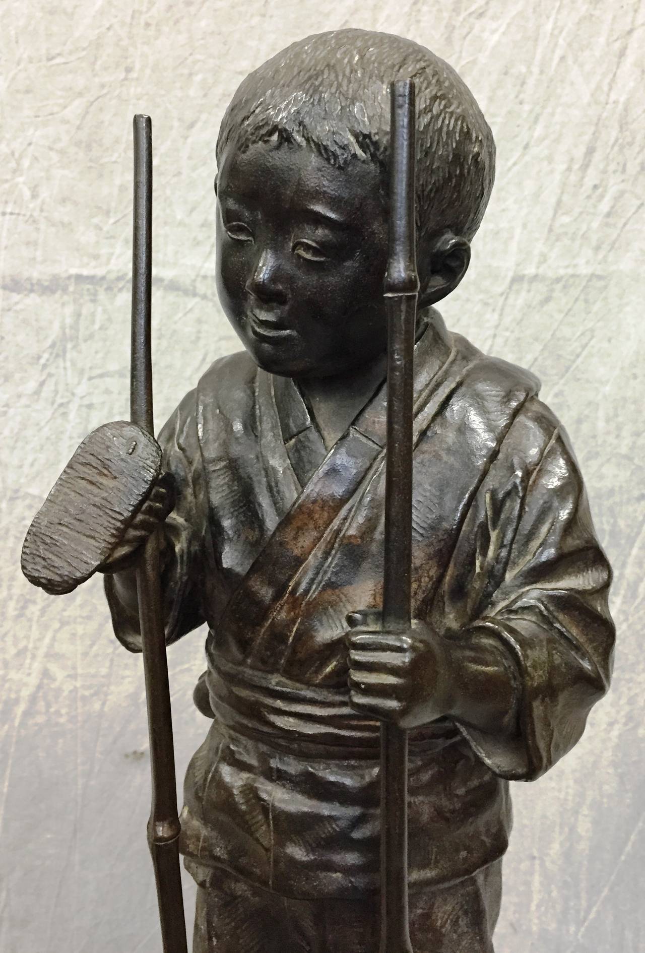 A very amusing Japanese bronze of a boy on bamboo stilts,
Meiji period (1868-1912).