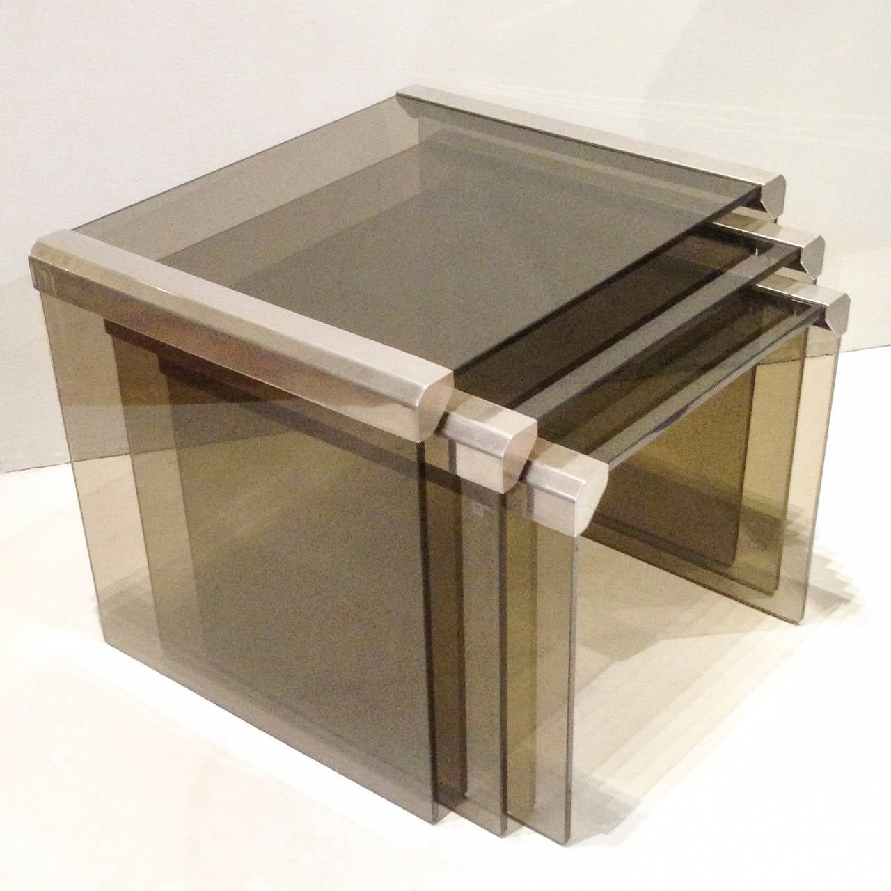 A Set Of Three Smoked Glass And Polished Steel Nesting Tables By Gallotti & Radice