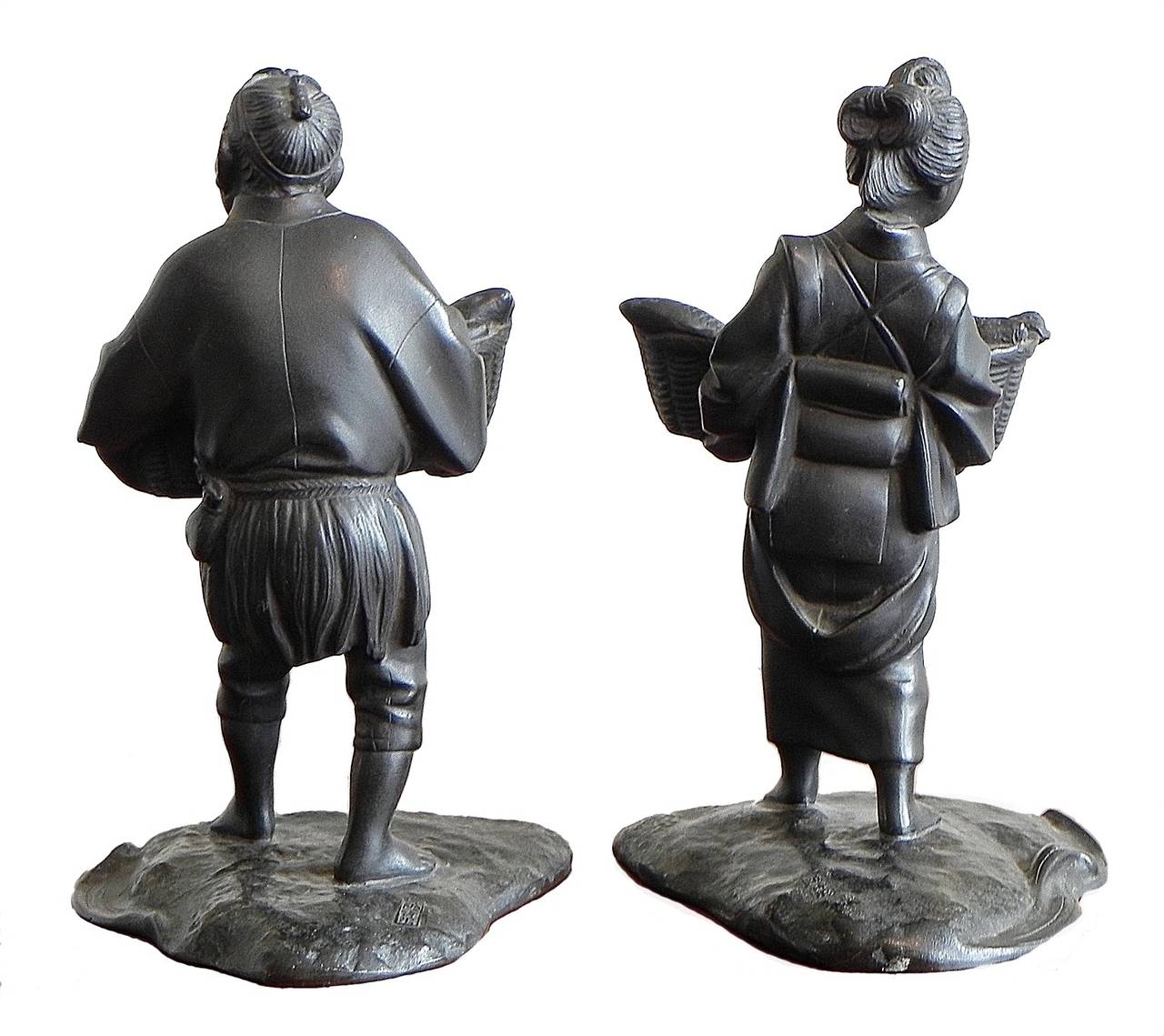 Pair of cast bronze bookends featuring a fisherman and wife carrying a basket of fish. Signed with character marks.