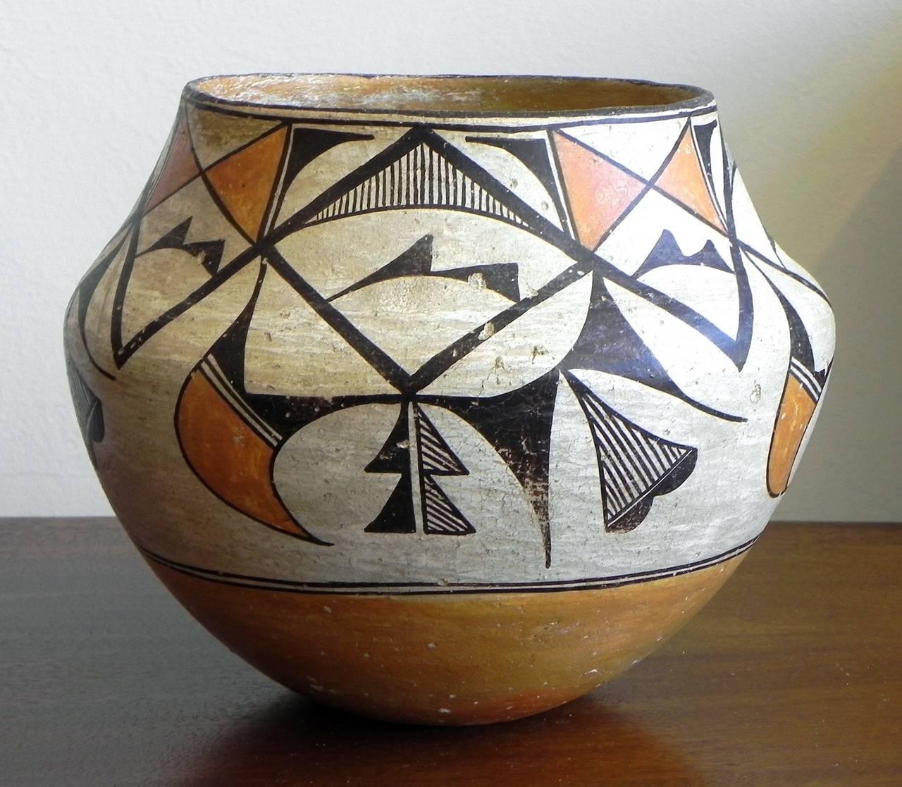 The Acoma pot having a repeating design of abstract foliate, feather and other devices in three colors. The flaring shoulder of the pot lends itself to this nicely proportioned southwestern storage jar.