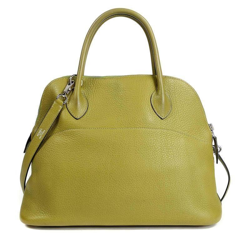 Hermes Vert Anis Clemence Leather 27 cm Bolide is in pristine condition, appearing never carried. The rounded top satchel is perfectly scaled and beautifully understated; a must have for any comprehensive wardrobe. Hermes bags are hand stitched by