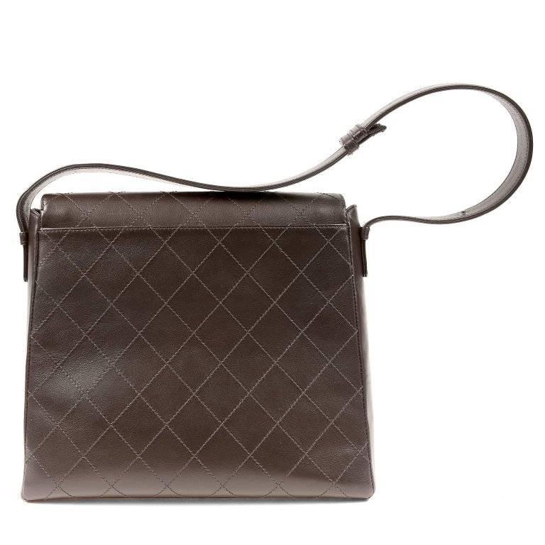 Chanel Brown Leather Flat Stitched Bag- EXCELLENT A simple style with classic lines, this piece has a very desirable versatility. Dark brown leather structured bag is stitched with signature Chanel diamond pattern. Dark brown metallic interlocking