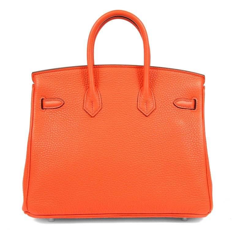 This authentic Hermes Feu Togo 25 cm Birkin Bag is in pristine unworn condition with the plastic intact on all hardware. Waitlists exceeding a year are commonplace for the intensely coveted classic leather Birkin. Each piece is hand crafted by