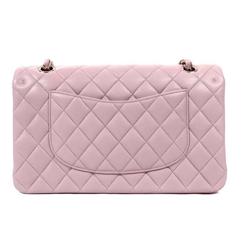 This authentic Chanel Lilac Lambskin Medium Classic Flap is pristine- never before carried. The timeless style is strikingly lovely in soft lilac with silver hardware. Feminine soft lilac lambskin is quilted in signature Chanel diamond pattern.