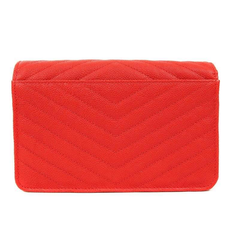 Chanel Red Caviar Wallet on a Chain WOC- NEVER CARRIED; Pristine Vivid and cheerful, this Wallet on a Chain is uniquely quilted in the chevron pattern- a rare find. Lipstick red textured caviar leather Wallet on a Chain (WOC) is quilted in chevron