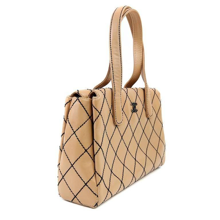 Chanel Beige Topstitched Tote- basically pristine, appearing never carried. Smart and sophisticated, this classic piece augments any ensemble with just the right amount of panache. Rich beige leather is accented with contrasting black topstitching