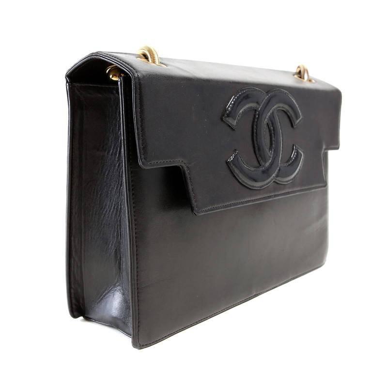 Chanel Black Leather Snake Chain Flap Bag is in nearly pristine condition. Very rarely carried and carefully stored, the unique style is a collector's dream. 
Structured smooth black leather bag has interlocking CC in black patent leather stitched
