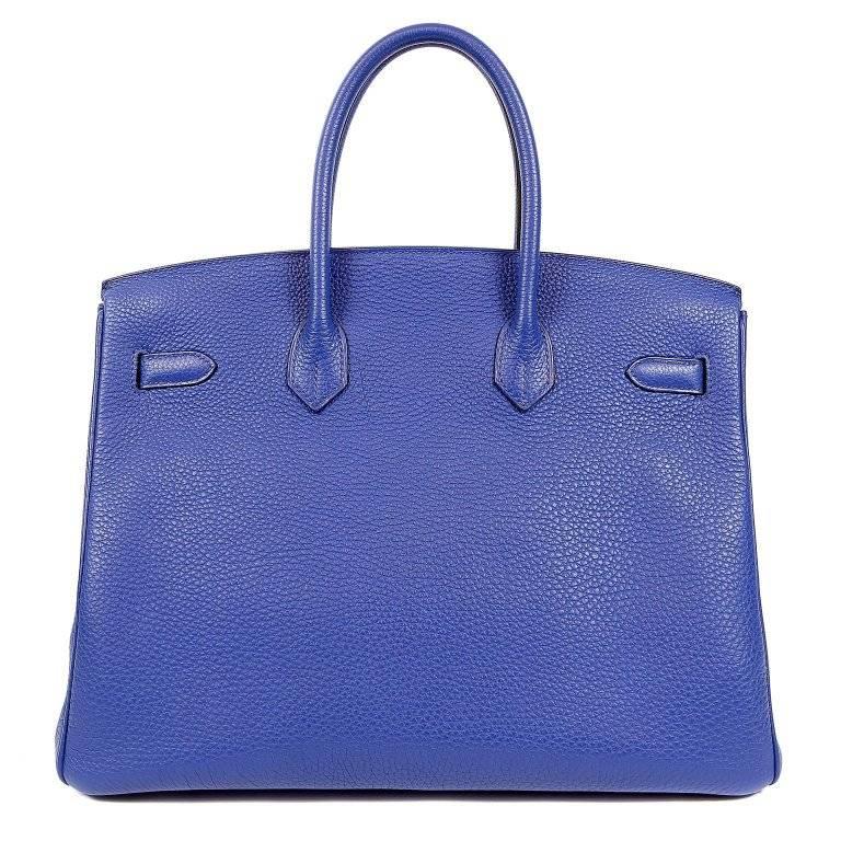 This authentic Hermes Blue Electric Togo 35 cm Birkin Bag is in pristine unworn condition with the plastic intact on the hardware. Waitlists exceeding a year are commonplace for the intensely coveted classic leather Birkin. Each piece is hand