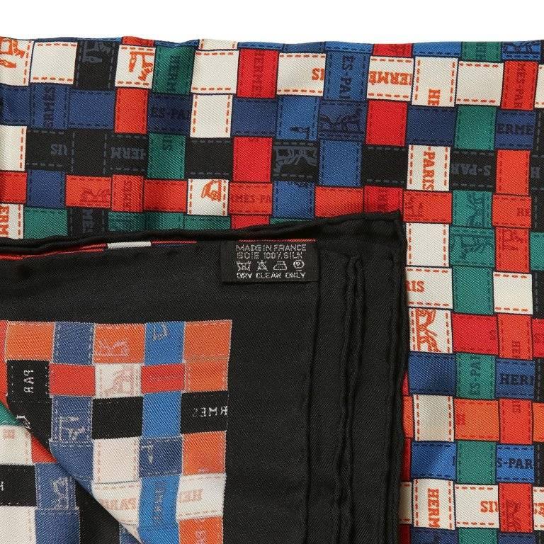 Hermes Red and Blue Bolduc au Carre 90 cm Silk Scarf- PRISTINE, Never Worn Designed by Cathy Latham, it depicts interwoven decorative Hermes ribbon in shades of red, blue, green, and white with a black border. 100% silk. Made in France. Hermes box