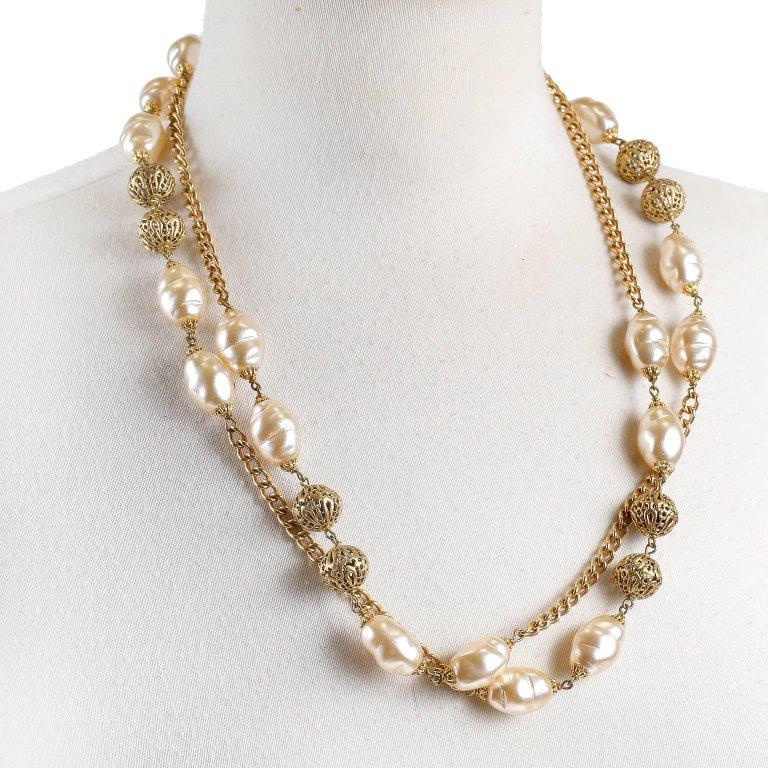 This authentic Chanel Baroque Pearl and Gold Chain Necklace is pristine.  A very beautiful piece that can be worn single or double layered, it is wonderful addition to any collection. Long gold link necklace with baroque pearl stations.  Gold