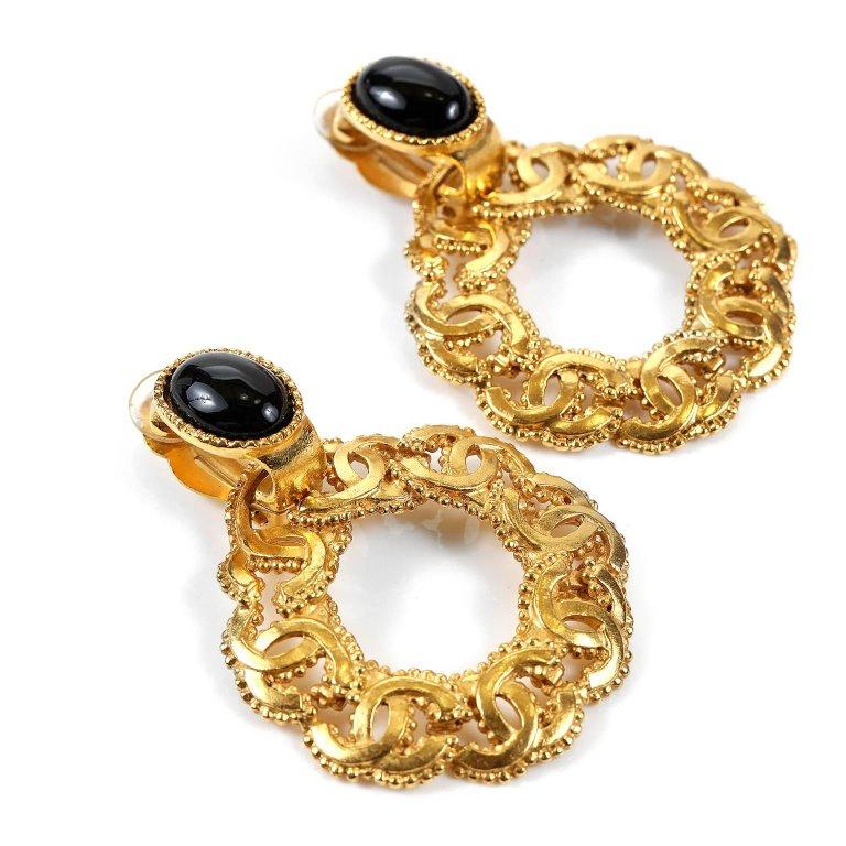 These authentic Chanel Gold CC Round Hoop Earrings are in mint condition.  Stunning gold CC clip on earrings make a bold statement with everything from tee shirts to gowns.  Large gold circle dangles from a black oval stone.  Circle created from