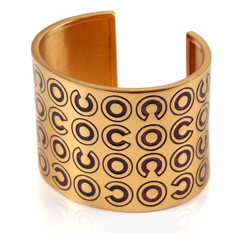 Chanel COCO Cuff  Bracelet is pristine. 
Matte gold wide cuff is covered in burgundy COCO lettering. Made in France.
 A214