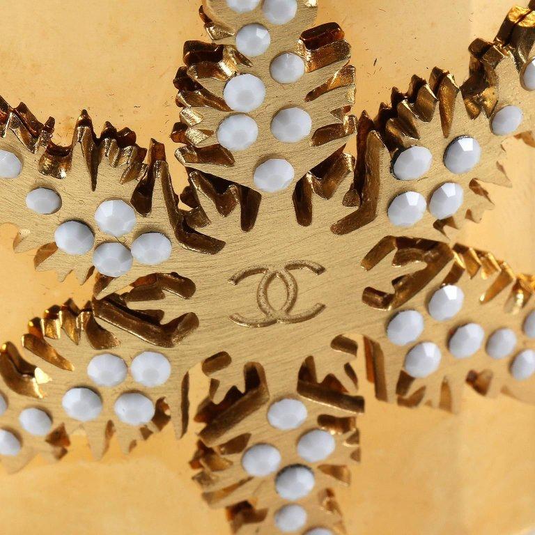 Chanel Gold Snowflake Cuff Bracelet - PRISTINE. 
Very rare and collectible with unique wintery theme. Wide hinged gold cuff has a large snowflake on the front.  Adorned with white faceted stones and central interlocking CC.  Hinged opening with