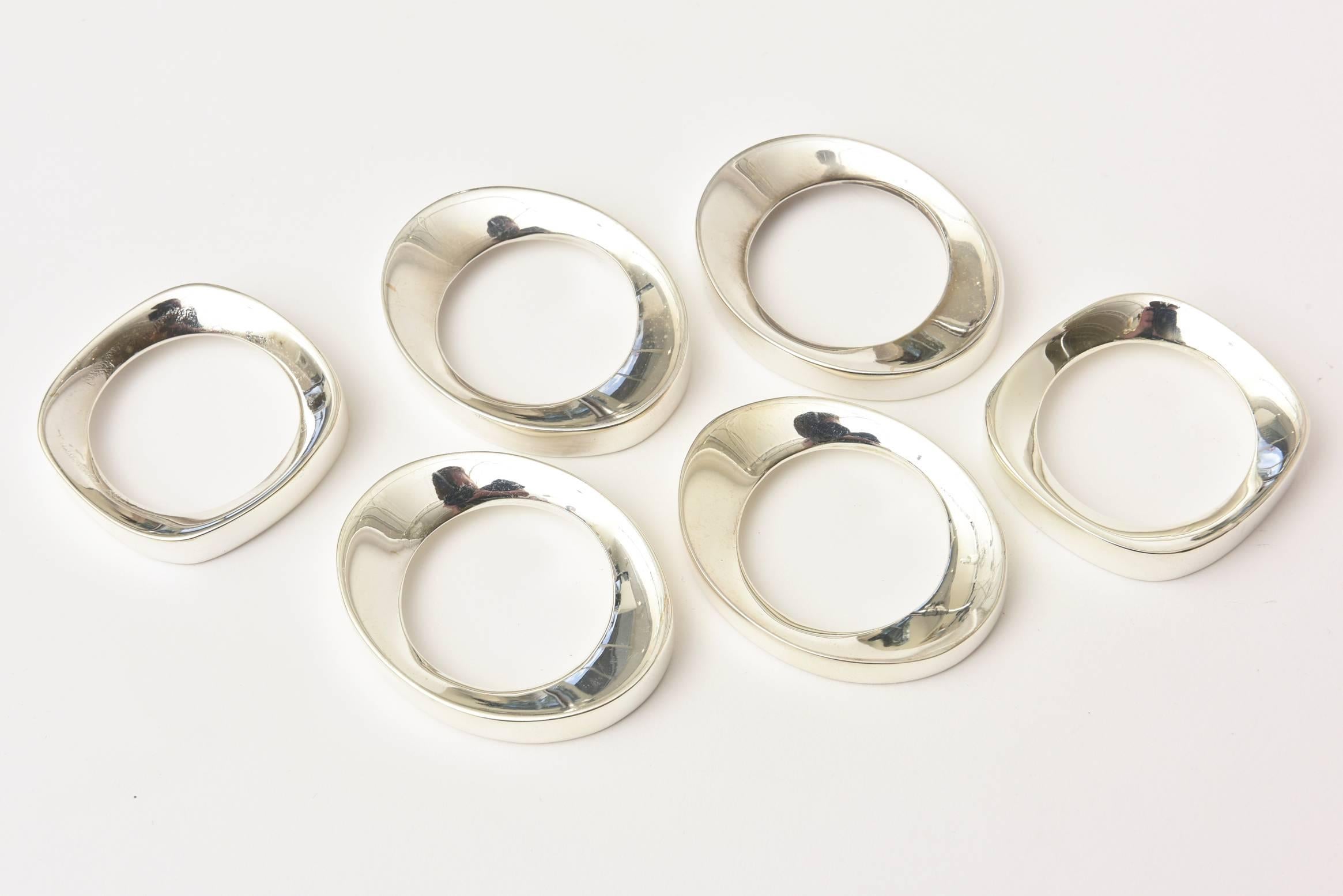 This set of six polished vintage silver plate sculptural napkin rings will set any table with elegance and modern elements. There are four of the same elliptical shape and two of another rounded square form. They have good weight to them and are