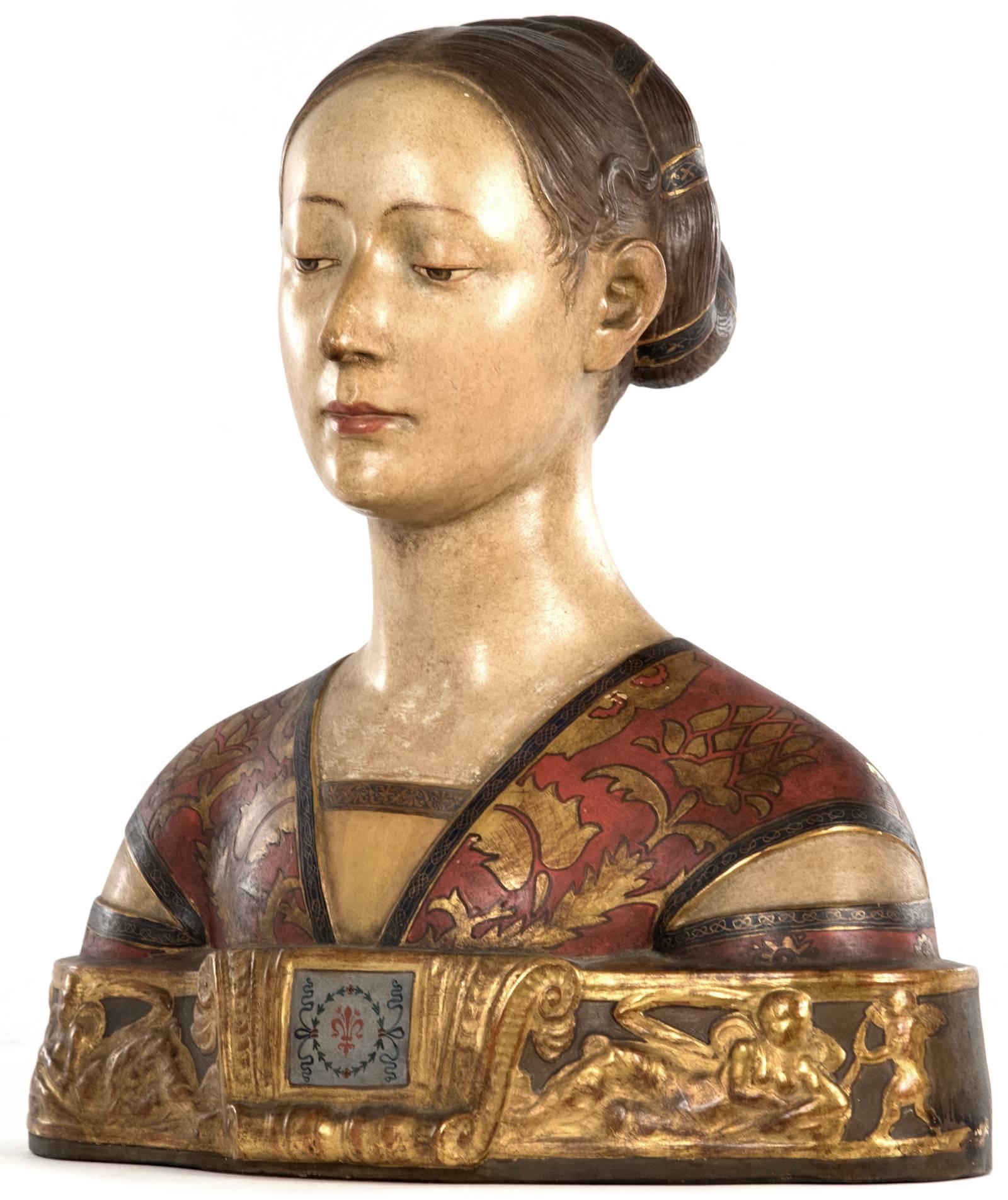 A late 19th century hand painted terracotta bust of a young woman, a princess of the House of Aragon after Francesco Laurana (1430-1502, Dalmatian), raised on an integral base designed with reclining figures and putti in relief. Inscribed to the