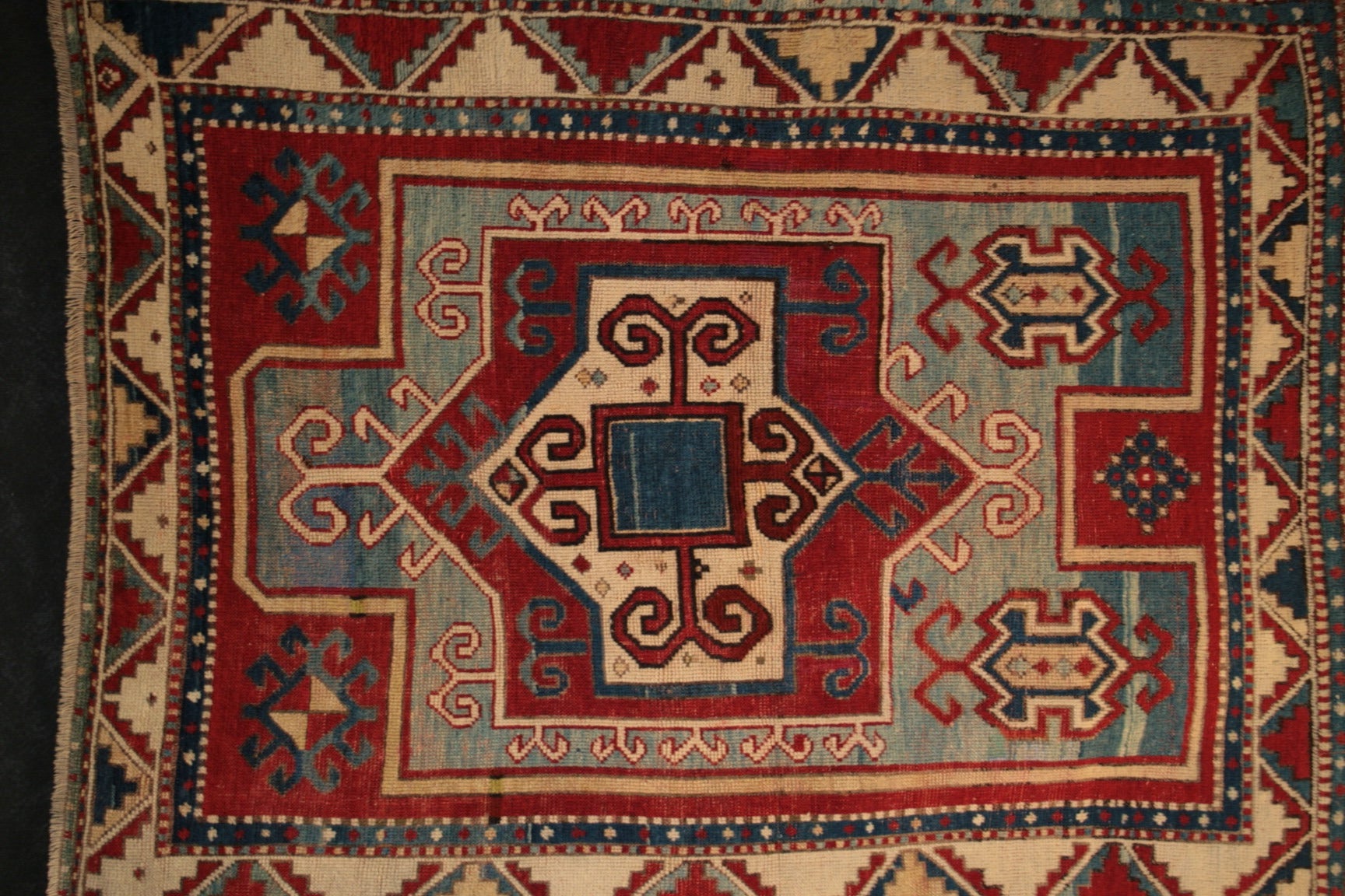 This rug was woven circa 1890-1900 in the Kazak district of Western Armenia.  The design is a distinctive prayer shaped motif, specifically attributed to the Fachralo Kazak carpets.  The medallion in the middle of the field is a classic design
