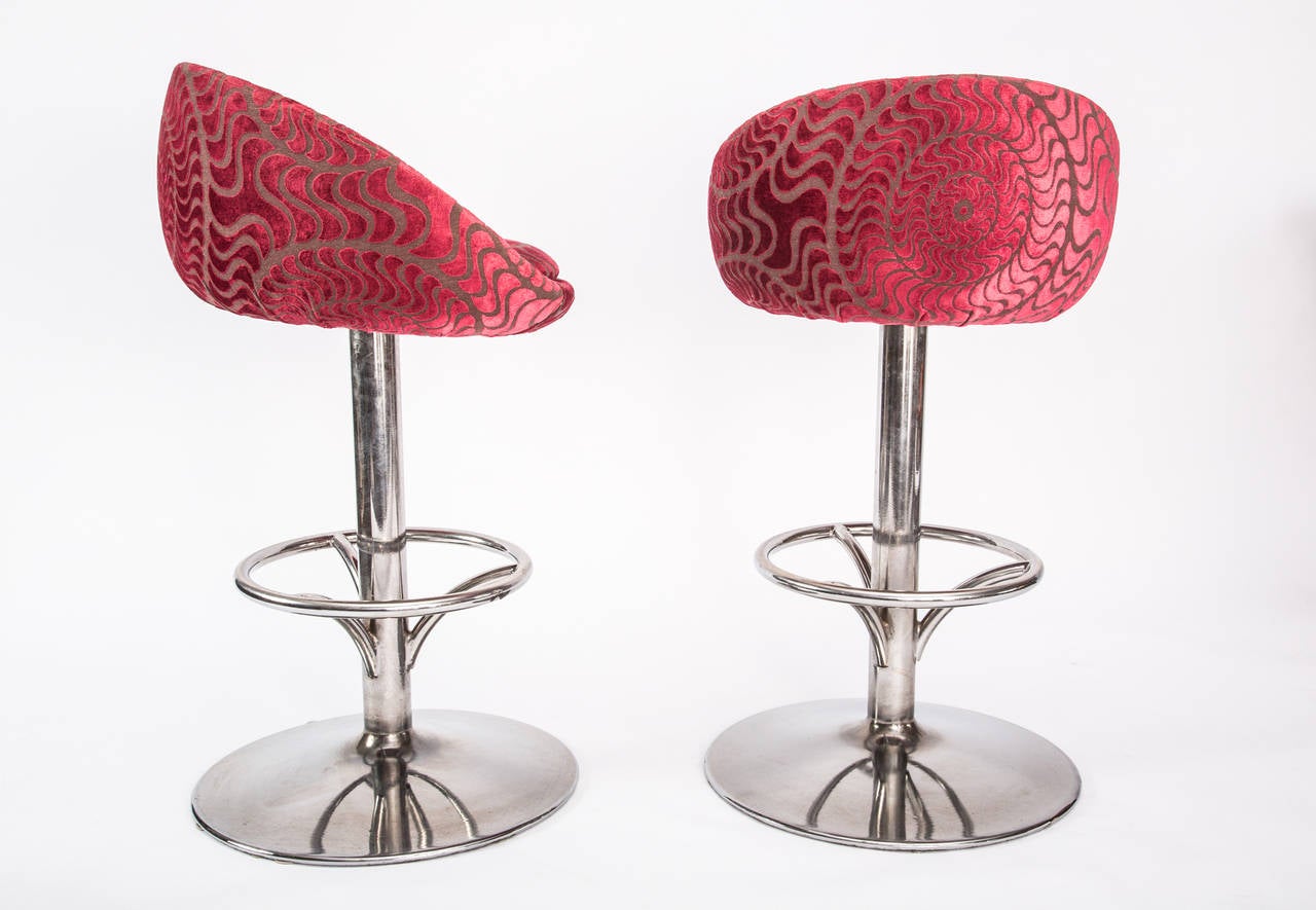 Pair of signature vintage-modern swivel bar stools with solid chrome finished pedestal and fuchsia velvet upholstered seat and low back by designer Christina Karras.