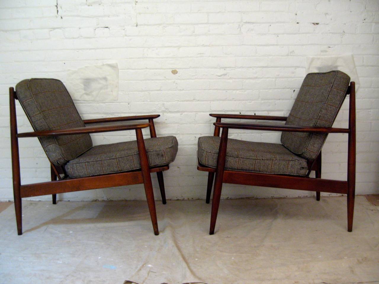 Excellent pair of Mid-Century Modern Baumritter lounge chairs, circa 1960. Unsigned. The frames are made of beech and ash. Amazing features include paddle arm, tapered legs and spindle backs. Still retains the original cushion fabric, but they do