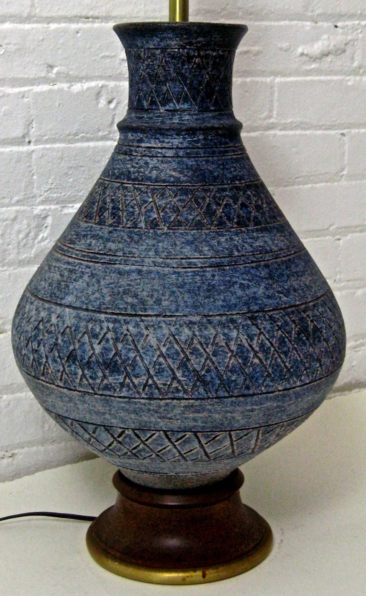 Decorated in a dark matte blue glaze with incised cross hatching design.  The quality and masterful gourd shaped design is reminiscent of Aldo Londi or Alvino Bagni for Bitossi.  Signed Italy.  The pottery is mounted on a turned wood base.  27"