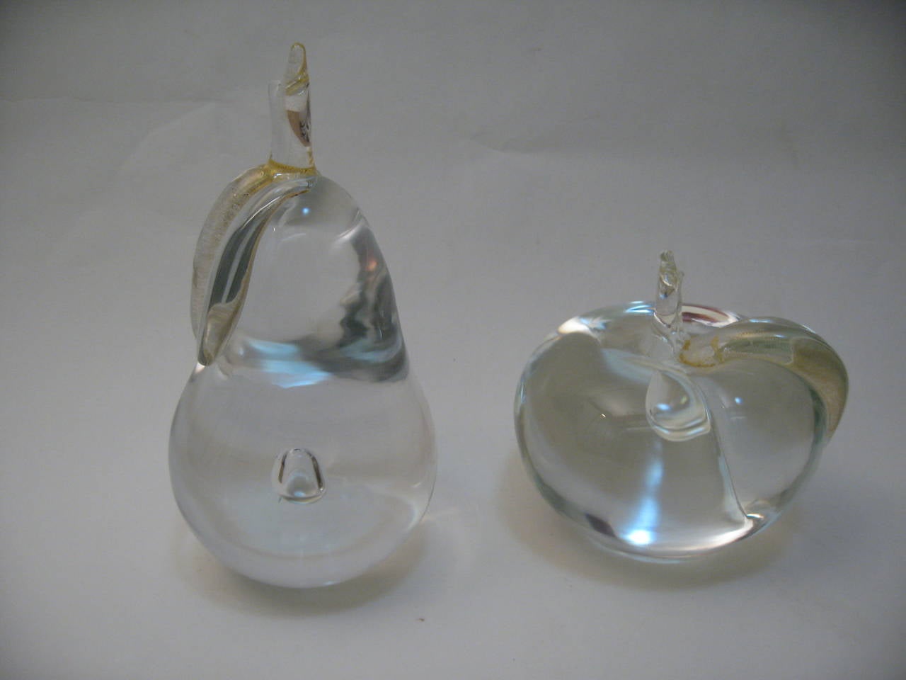 Beautiful set of Italian art glass bookends/paperweights with gold inclusions. The pear and apple are all handblown glass with polished pontils and controlled bubble in each. The gold inclusions are in the leaves of both pieces. Excellent, original