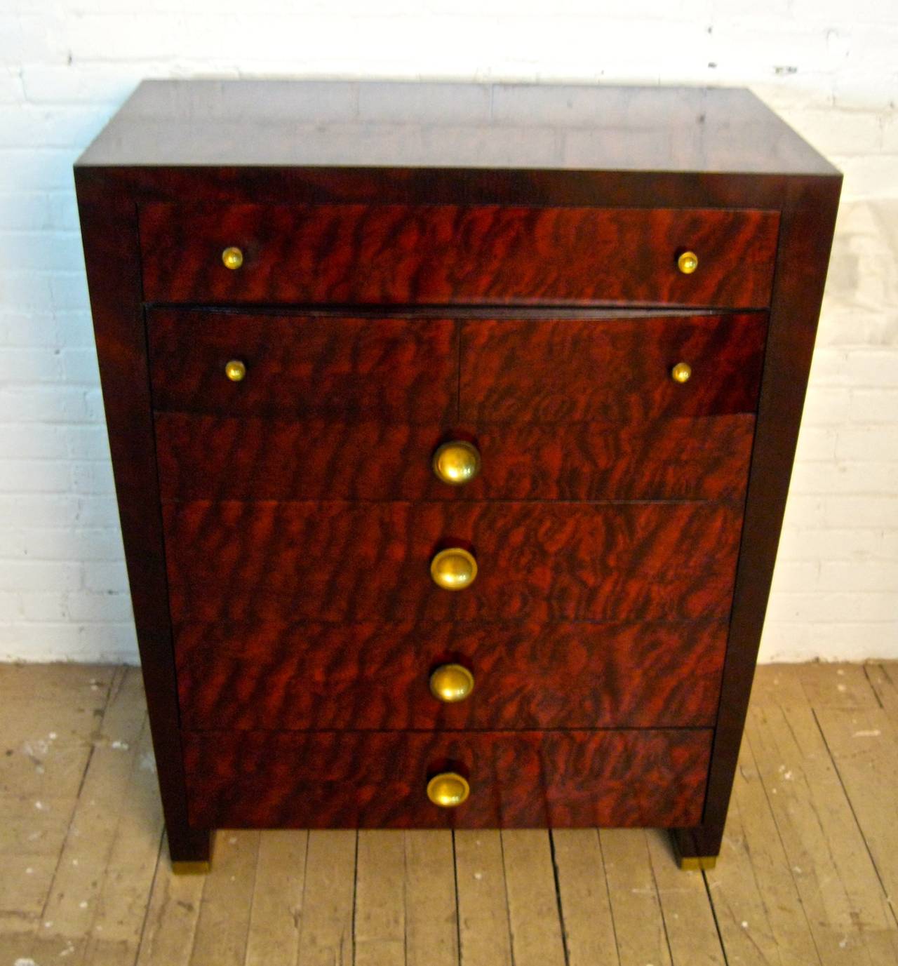 Simple and finely tapered Art Moderne quilted and figured maple six-drawer dresser, circa 1940-1950. Brass finished hardware and brass feet. Deep storage. The second drawer has a bow front. Excellent, dark original finish. The piece measures 36