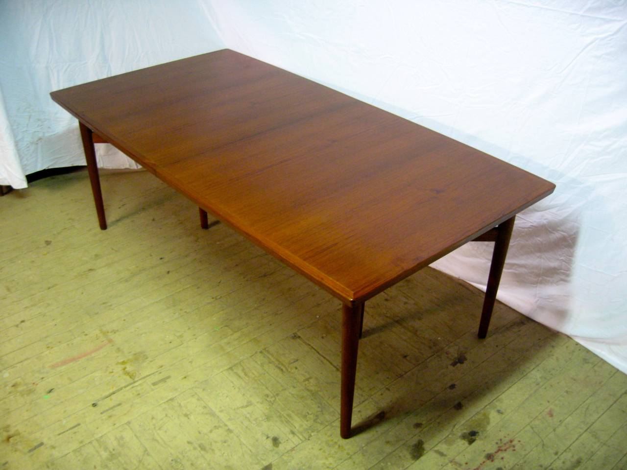 A table that goes on forever when extended...Early refined design by Arne Vodder for Sibast Mobler.  Solid teak edge and legs with wonderfully matched figured veneers.  Very gradual bow detail on two sides. Two wide leaves that measure 19.5