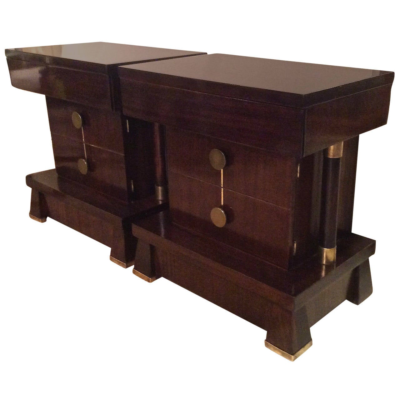 Fabulous pair of Art Deco mahogany nightstands or side tables with columnar mahogany support on either side. Table doors open to reveal an inner shelf. Stunning brass details adorn the plinth feet, doors and pulls. Professionally hand polished.