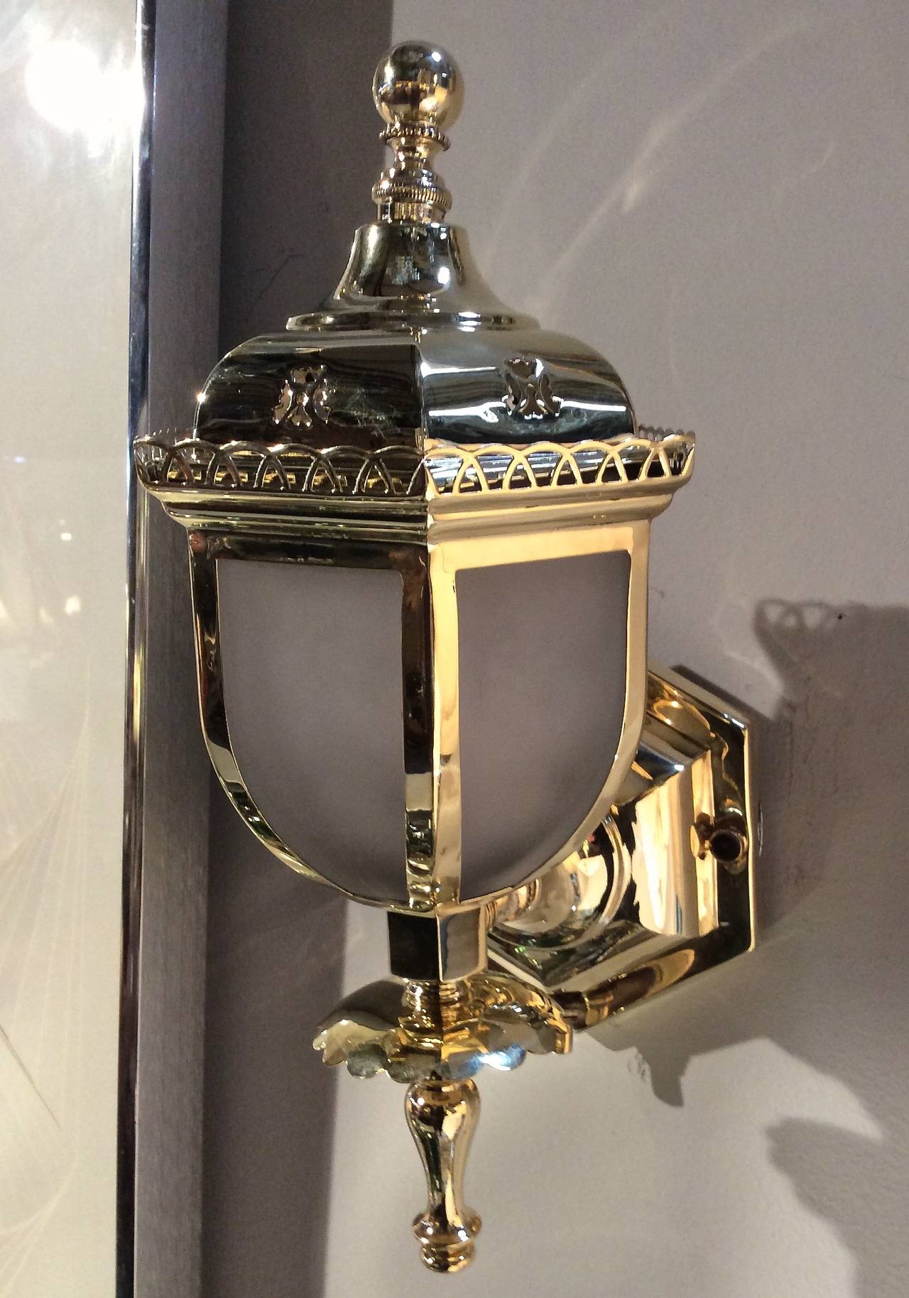 Amazing set of four antique solid unlacquered brass lantern style sconces, with six panelled solid cast glass shades. Intricate metal detail and frosted solid cast glass shade is an amazing 1/4 thick. Top has detailed pagoda like brass covers.