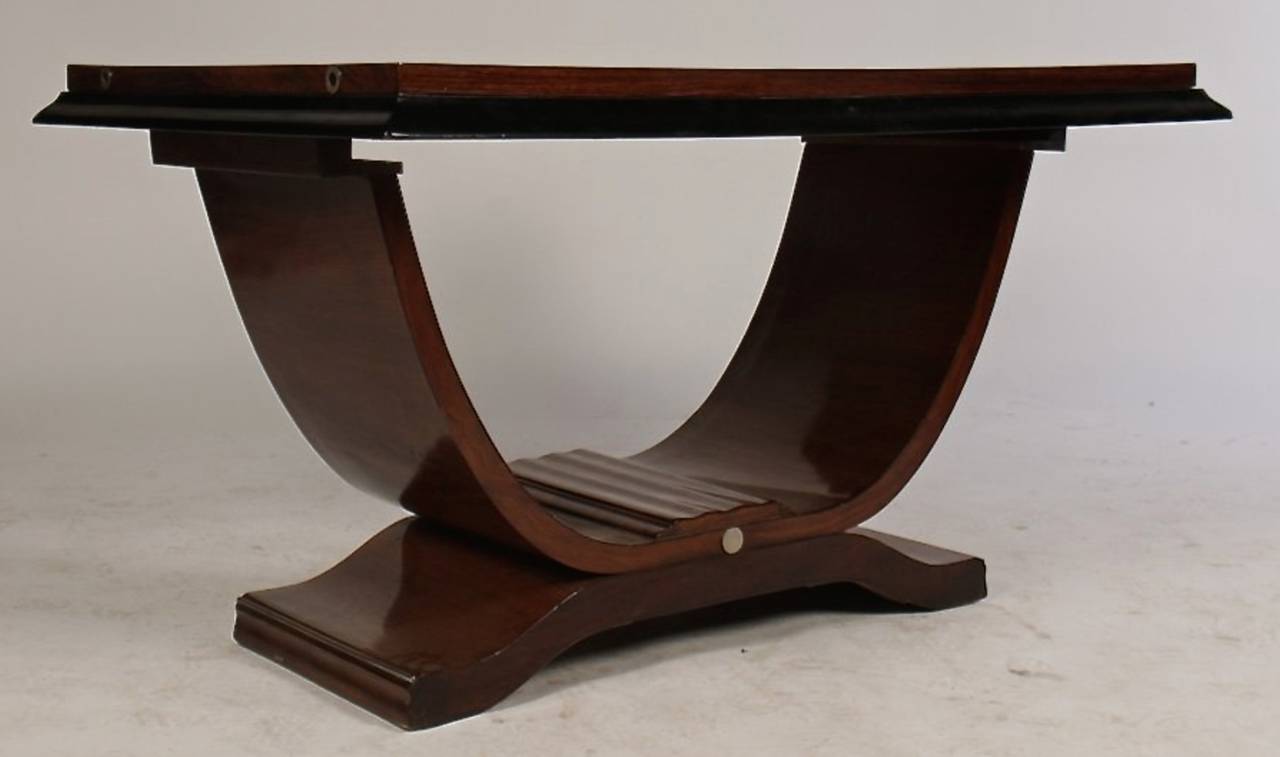 Striking Art Deco table with a stepped and molded top and ebonized overhang, raised on a curved platform base, circa 1940. This stepped up top has a magnificent grain and finish, that is complemented by a graceful platform that has a nickel detail