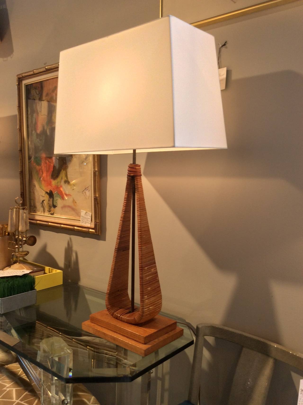 Vintage pair of sculptural cane lamps, style of Frederic Weinberg or Arthur Umanoff. Tear drop form bodies wrapped in lacquered wicker, with oak tiered plinth bases. Concealed (new) wiring in iron rod and finished with bamboo finial. 
Dimensions