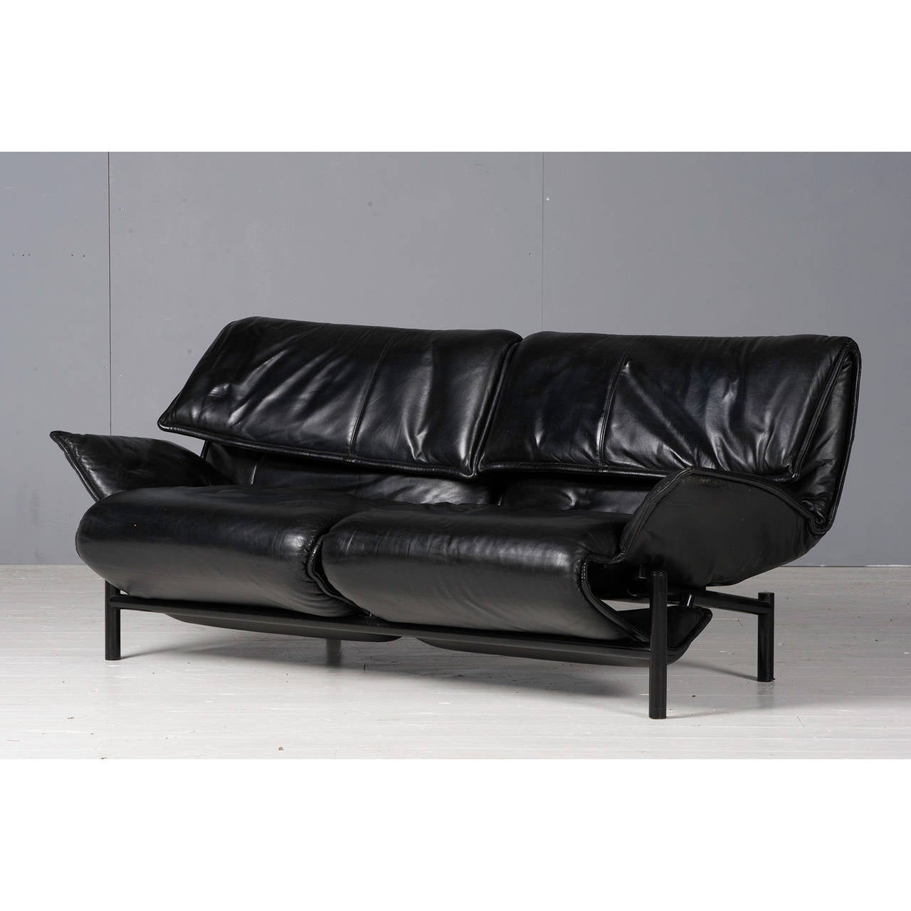 The 'Veranda' Sofa designed by Vico Magistretti for Cassina in 1983. This sculptural chair can be adjusted into several positions using a spring mechanism and operated by a control lever with folding headrest. Original leather black upholstery,