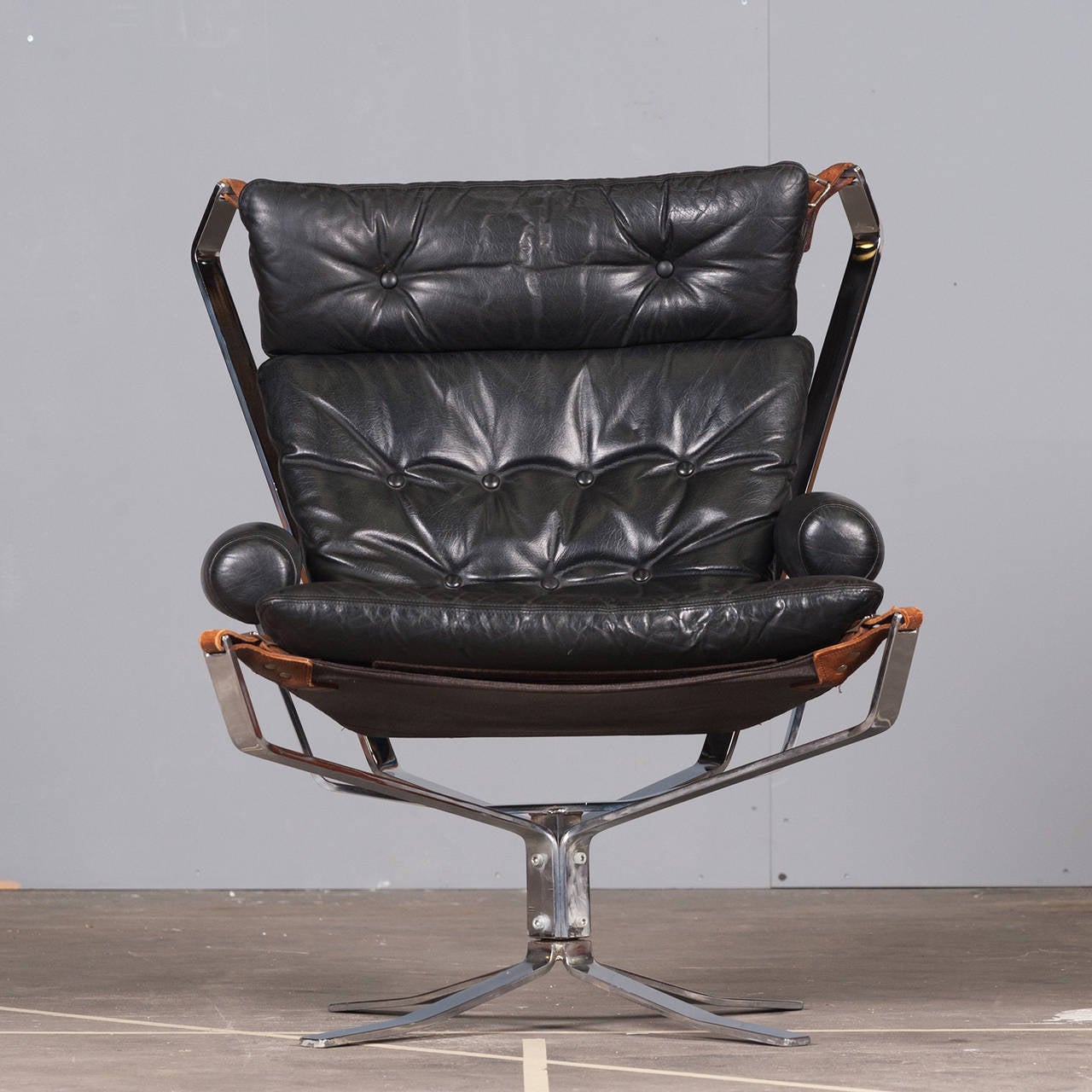 The High Back Falcon Chair is an iconic Norwegian design piece. Originally designed in 1971 and manufactured by Vatne Mobler Norway. With a light appearance, hammock style seat, vintage leather cushioning and solid steel frame, this impressive piece