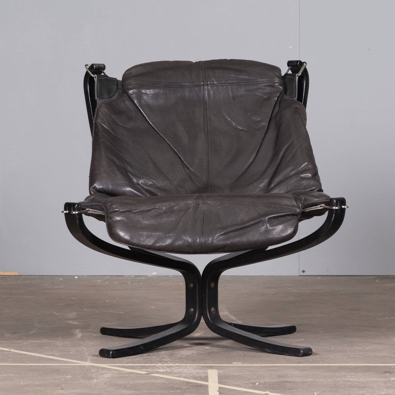 The High Back Falcon Chair is an iconic Norwegian design piece. Originally designed in 1971 and manufactured by Vatne Mobler Norway. With a light appearance, hammock style seat, vintage leather cushioning and solid steel frame, this impressive piece