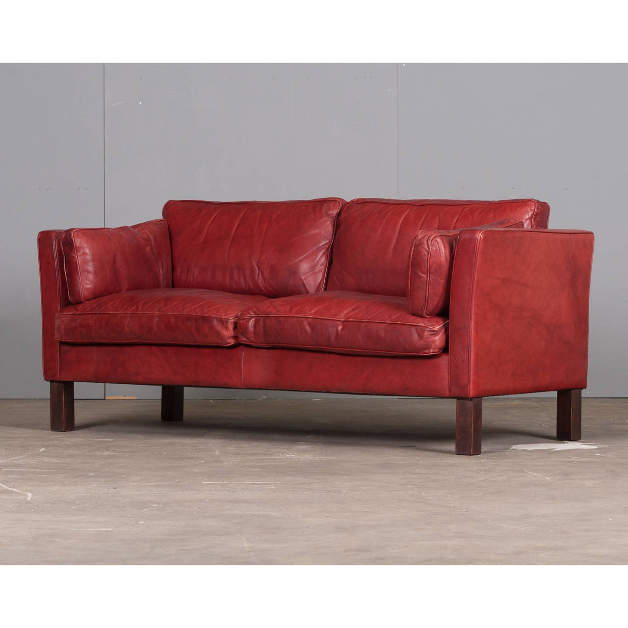 What a beauty! This stunning piece features the classic style of a Mid-Century Modern Danish sofa with an exceptional colour by Arne Norell. A striking cherry-red coloured leather, this sofa is both stylish and comfortable and in superb condition.