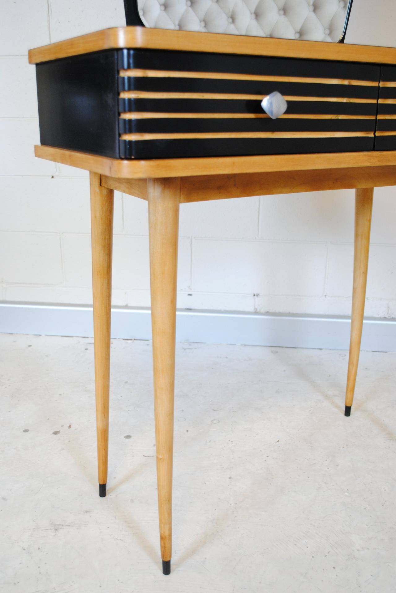 French 1950s Ebonized and Birch dressing or vanity table with asymmetrical mirror and typical tapered legs. With two drawers.