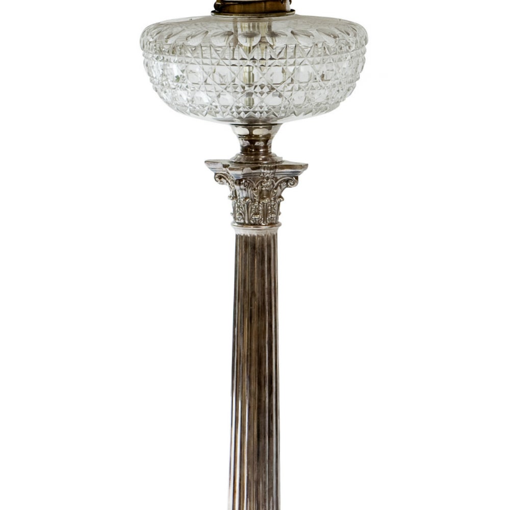 A 19th century neoclassical silver plated converted oil lamp by James Hinks & Son. The base takes the form of a Corinthian column decorated with a crown of laurel leaves above a stepped base. The capital of the pillar is topped with an ovoid crystal