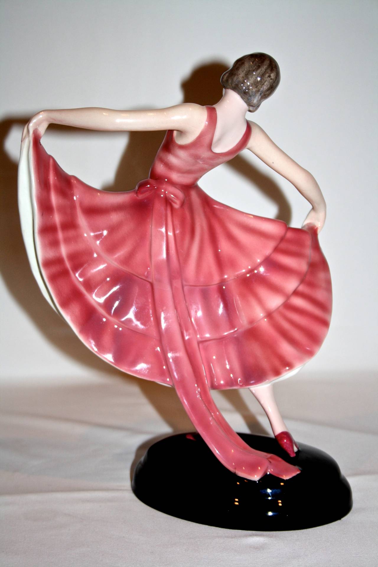 Here we have a wonderful figure by Stephan Dakon for Goldscheider ceramics
made in Austria, circa 1930 Model number 6020.
She wears a highly stylized pink dress with a multitude of hand-painted flowers
the figure also features a polychrome