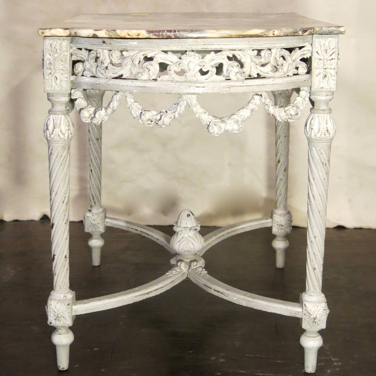 Antique French 19th century Louis XVI style table with curved sides, detailing on all four sides, and original marble with colors of grey, tan, and aubergine.