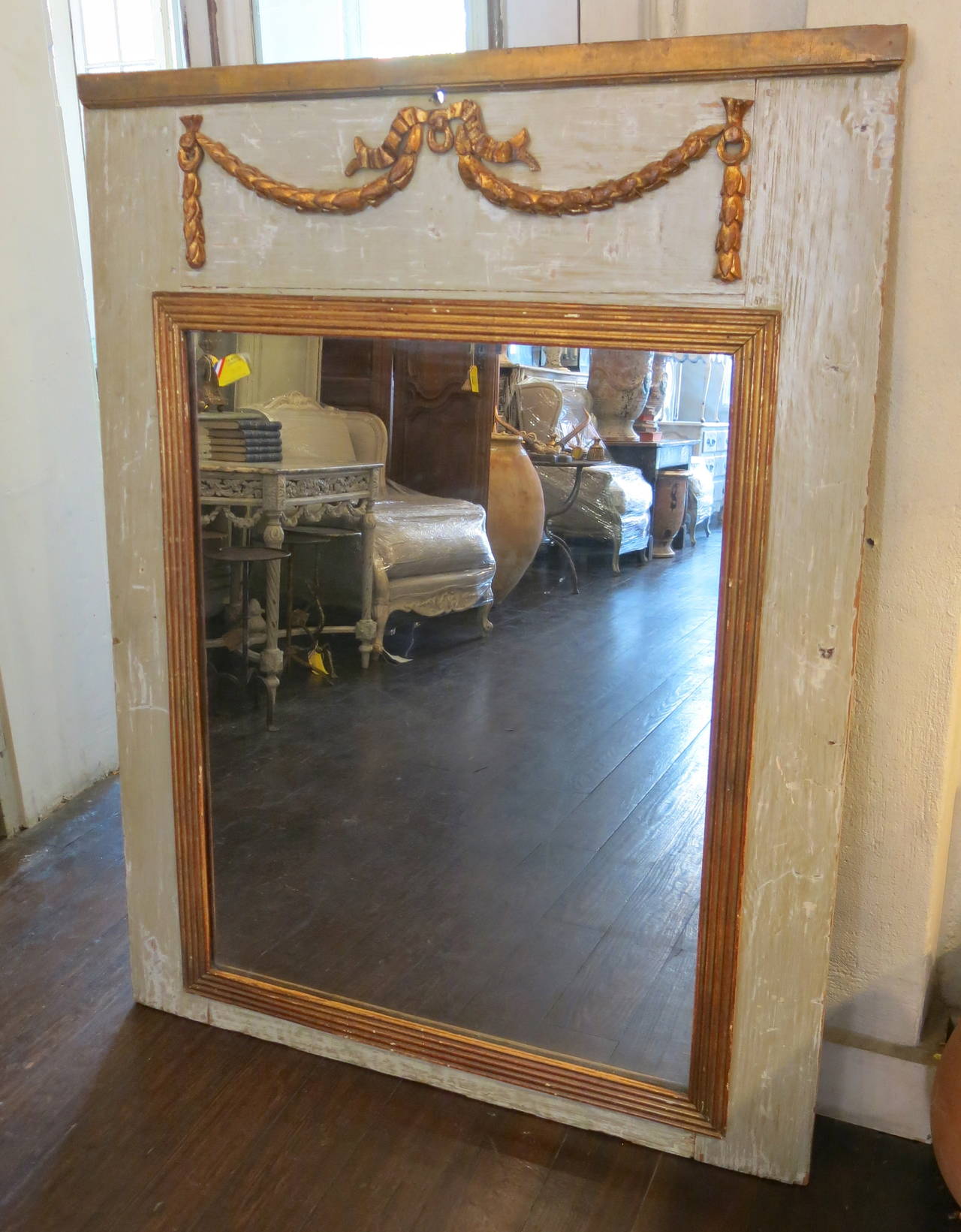 Rare 19th century period Directoire trumeau mirror with original carvings, original gilded frame, and original mercury glass.