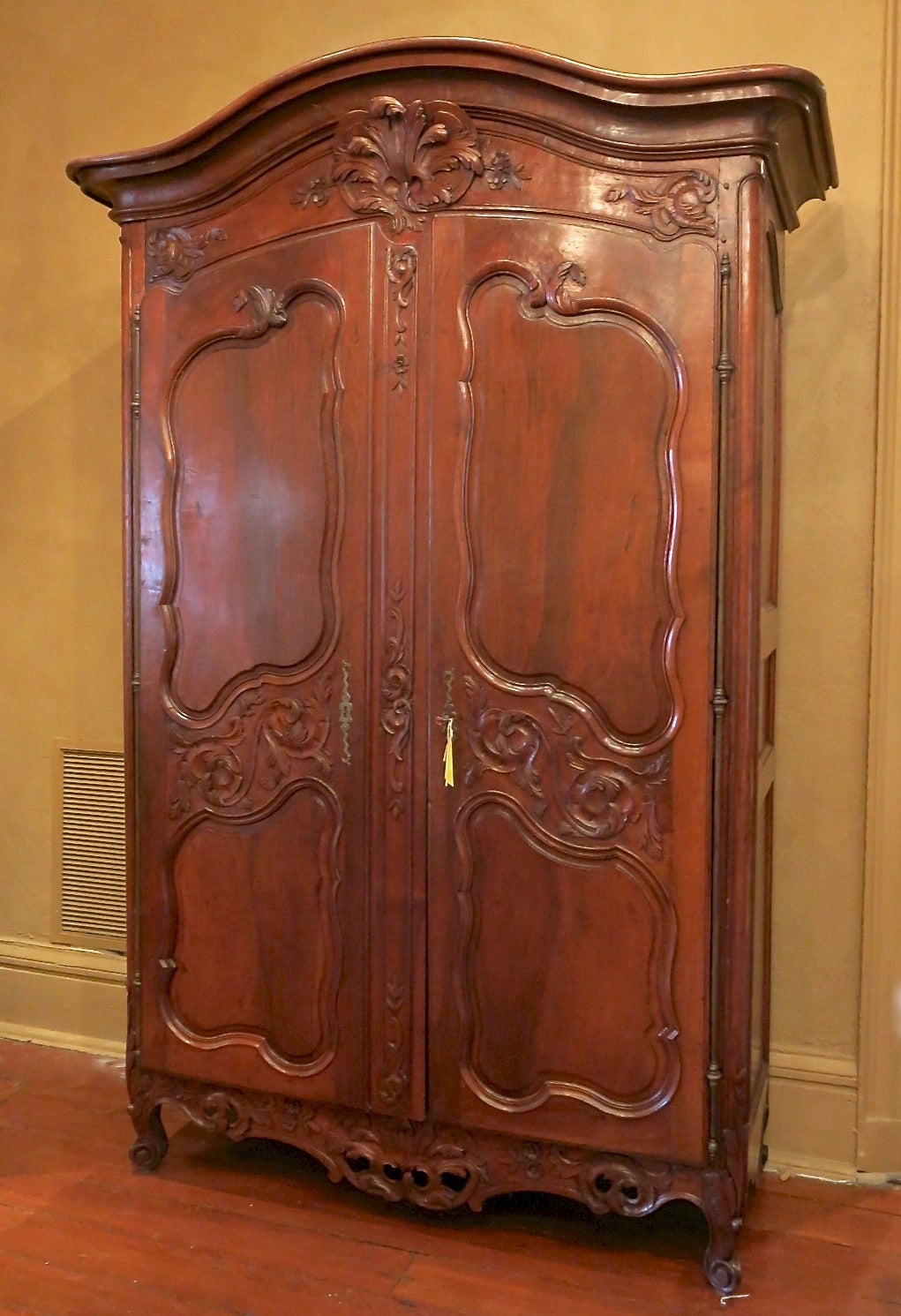 Antique French 18th century period Regence walnut armoire, with detailed carvings, curved bonnet, curved doors and original full length pewter hinges.