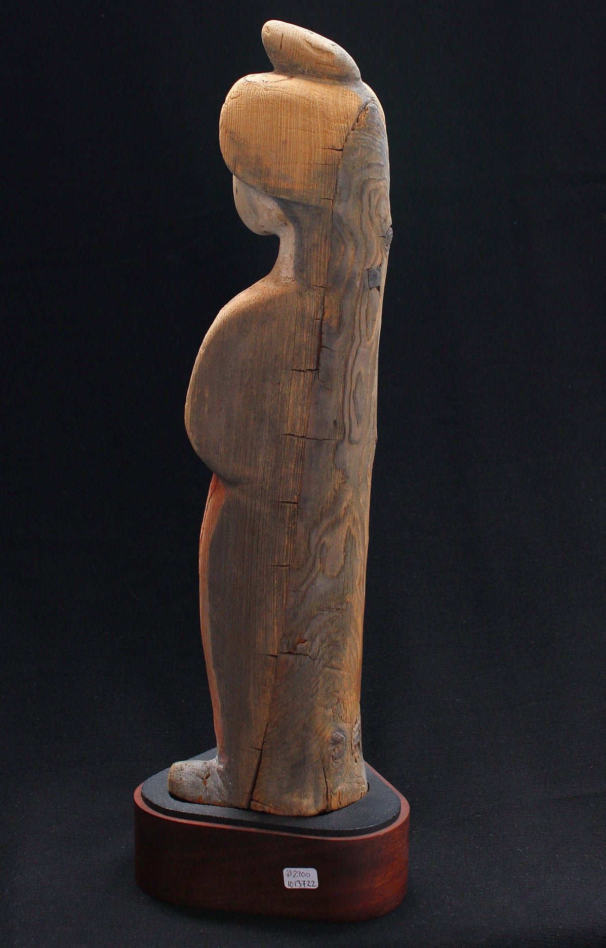 Chinese carved wood figure of a court lady, standing dressed in flowing robes with hands clasped, her hair in a high hairdo.      
Tang dynasty,      
8th century AD.   

-----------------
Unusual wood version of the usual pottery court lady.