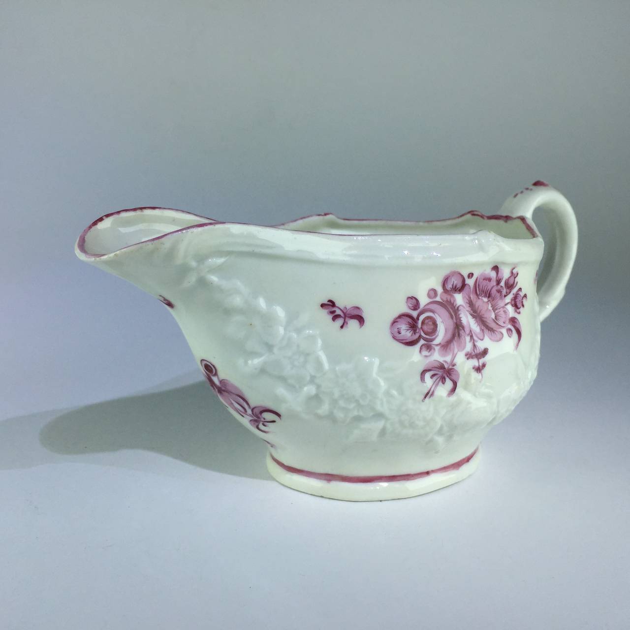 Rare Bristol sauceboat, moulded with flower swags and painted in puce with flower groups.       
circa 1775.