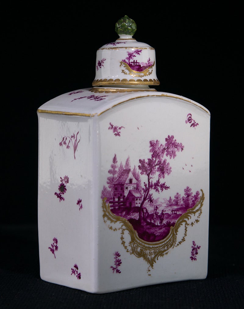 Rare Frankenthal tea canister & cover, painted to either side with superbly detailed European landscapes in purple, within asymmetric rococo scroll panels in gold, the ground with scattered purple flower sprigs, the rare lid with green artichoke