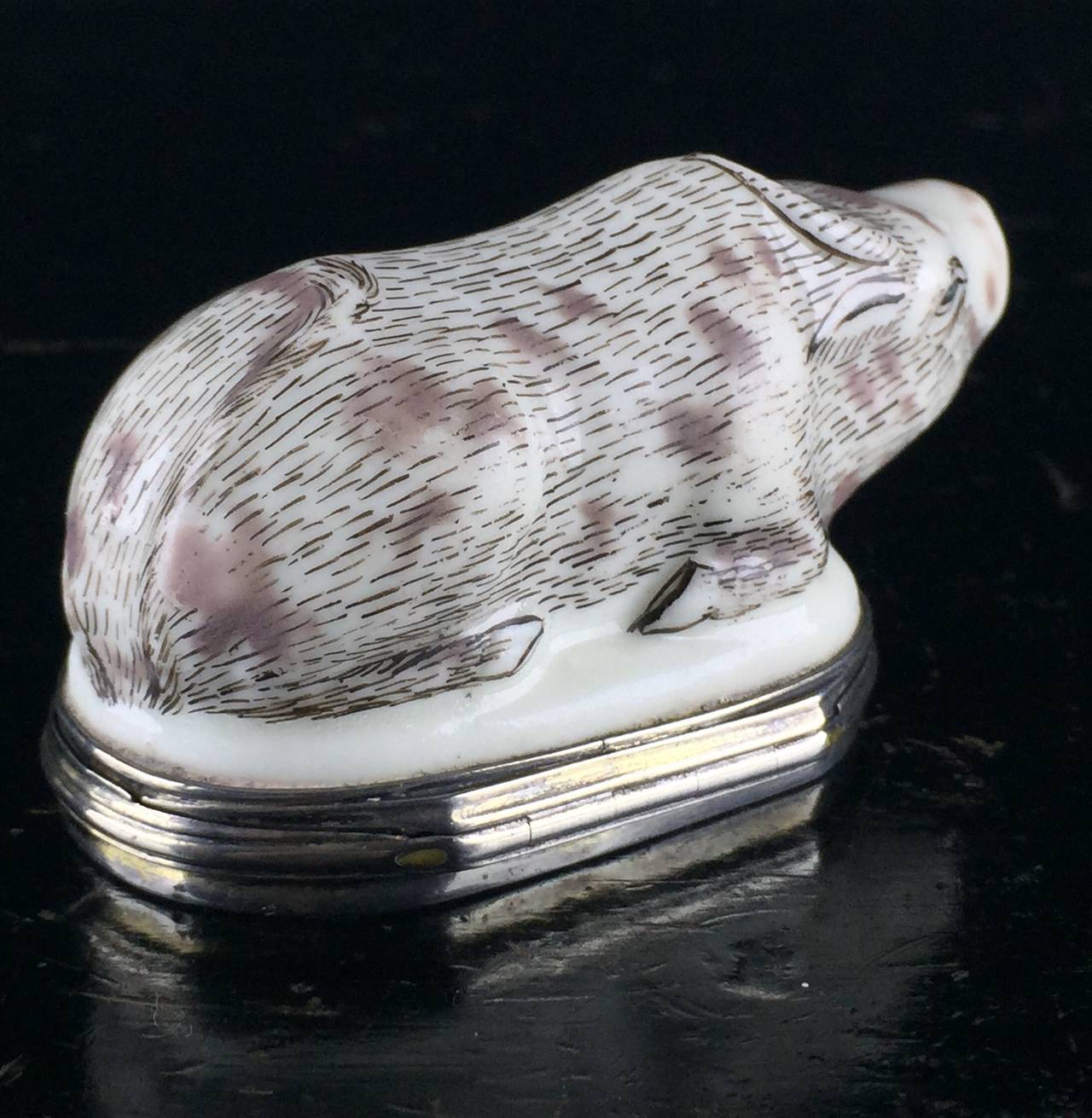 Saint cloud snuff box, modelled as a reclining water buffalo, with details picked out in brown and black, having blue eyes and red mouth, the lid with colorful chinoiserie decoration to either face, the outside with a seated figure, the interior