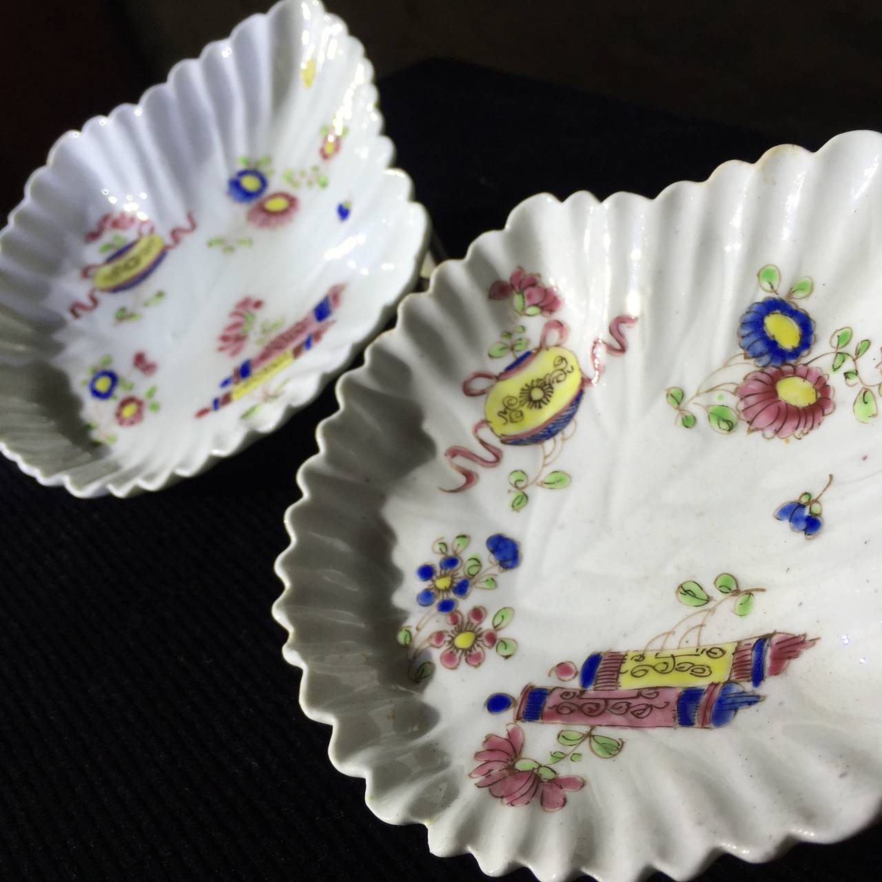 Pair of Bow pickle leaf dishes, of unusual fluted form, painted with 'precious objects' in bright famille rose colours, circa  1755