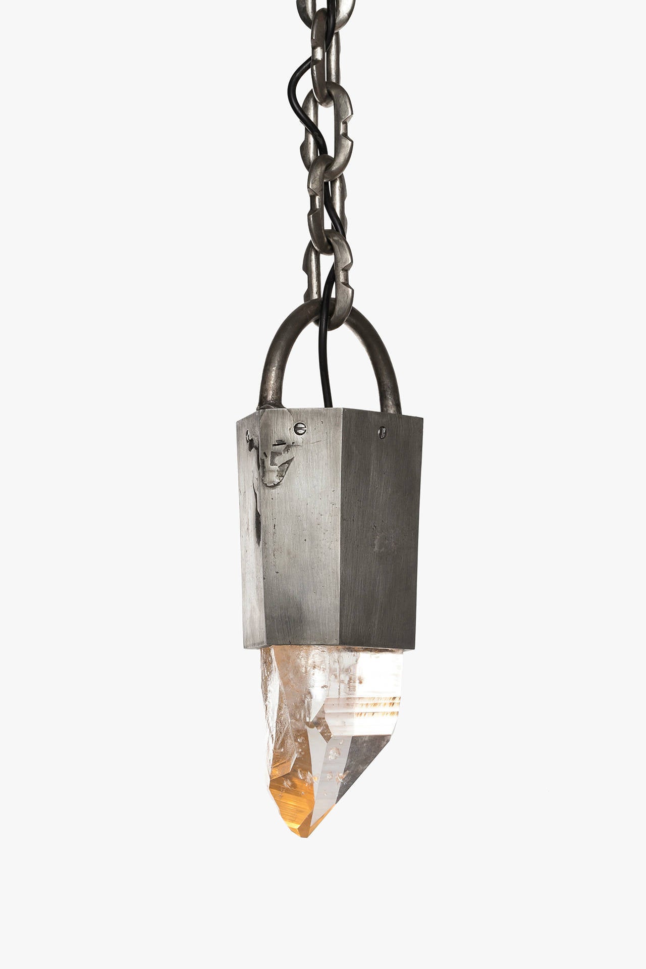 Pendant II by P4H (Parts of Four Home) features a 2.36 kg Lemurian quartz crystal illuminated by hidden LED's set into a hand-fabricated iron canopy with acid patina finish suspended by a white bronze chain. 

P4H (Parts of Four Home) is a