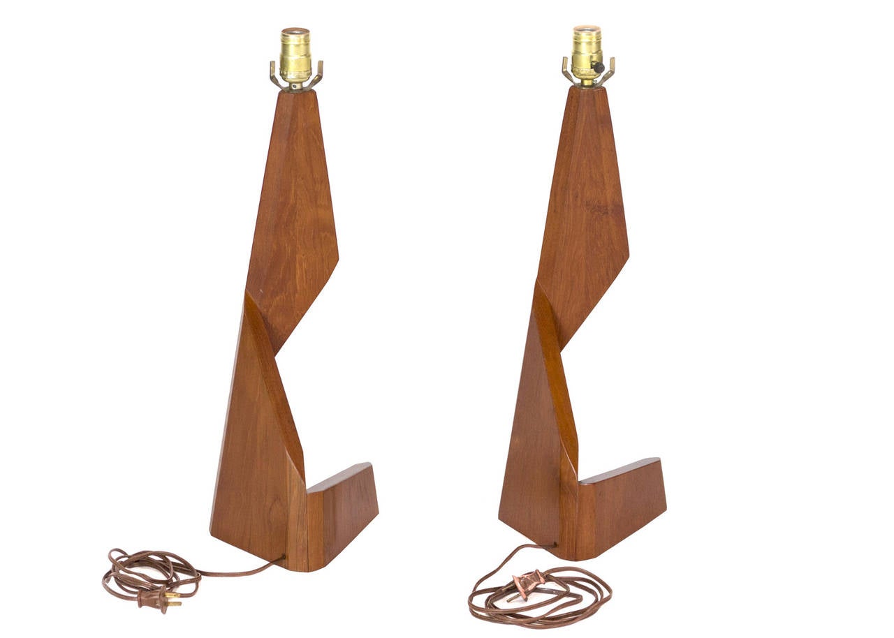 Pair of sculptural Danish table lamps by George Tanier. 

These lamps feature a unique triangular design made from stained wood. 

 