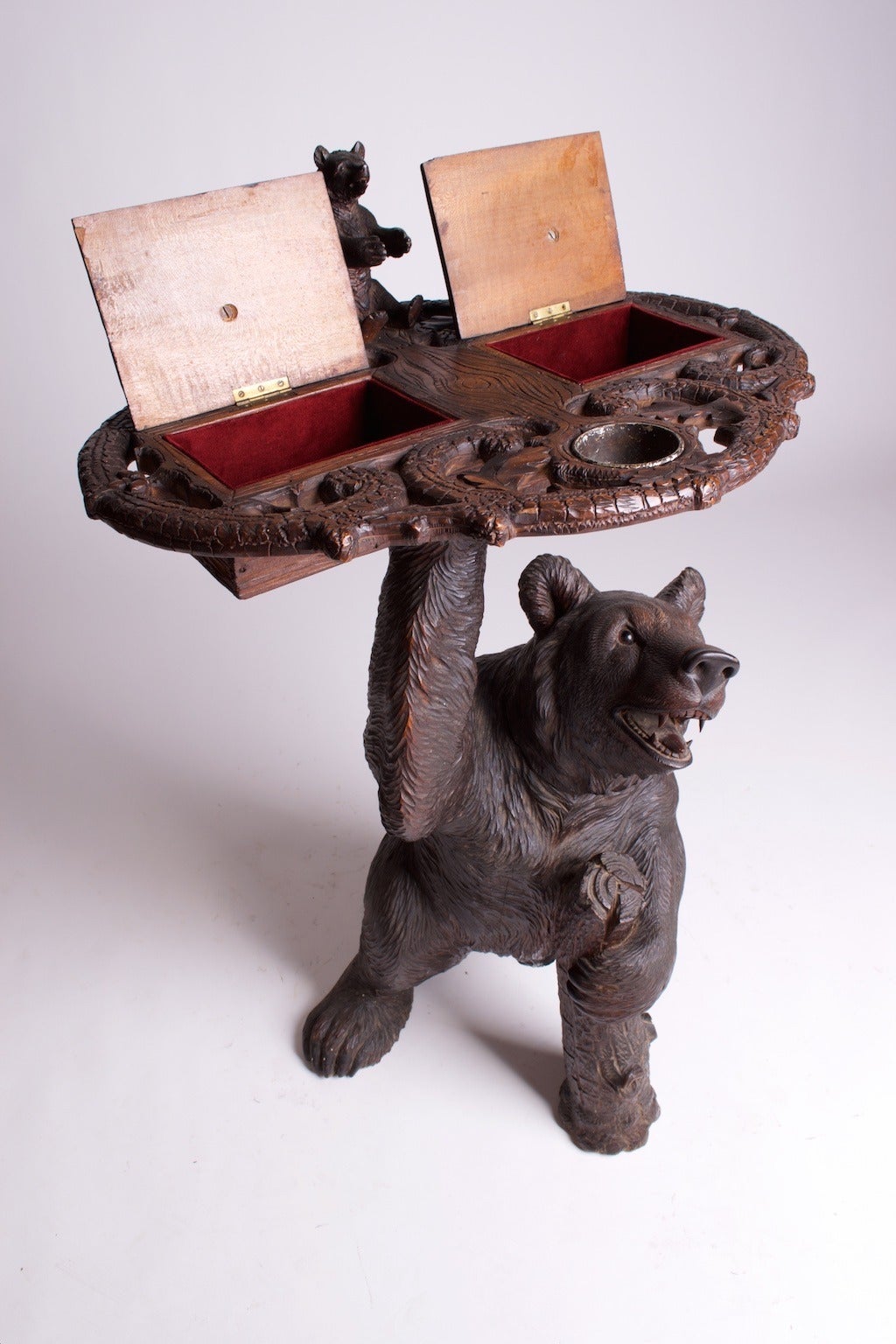 A finely carved Black Forest bear smokers stand in walnut with glass eyes, circa 1880, Brienz, Bernese Oberland, Switzerland.

Literature: Brienz Bernese Oberland, Switzerland.